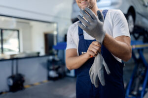 unrecognizable mechanic using working gloves at auto repair shop