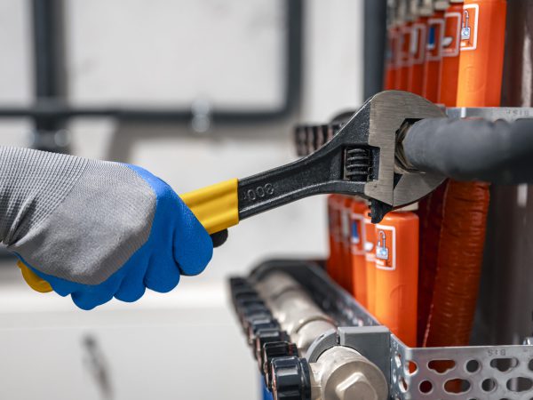 male hands with a wrench turning off valves.
