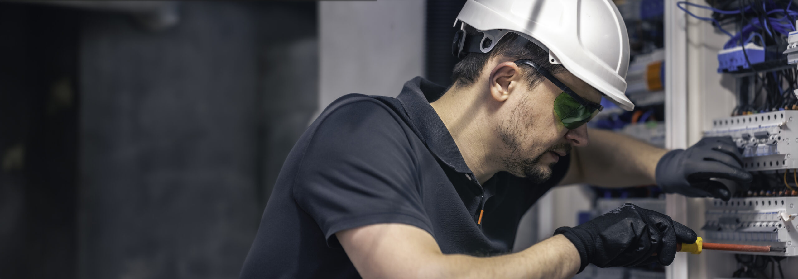 male electrician works switchboard using electrical connection cable (1)