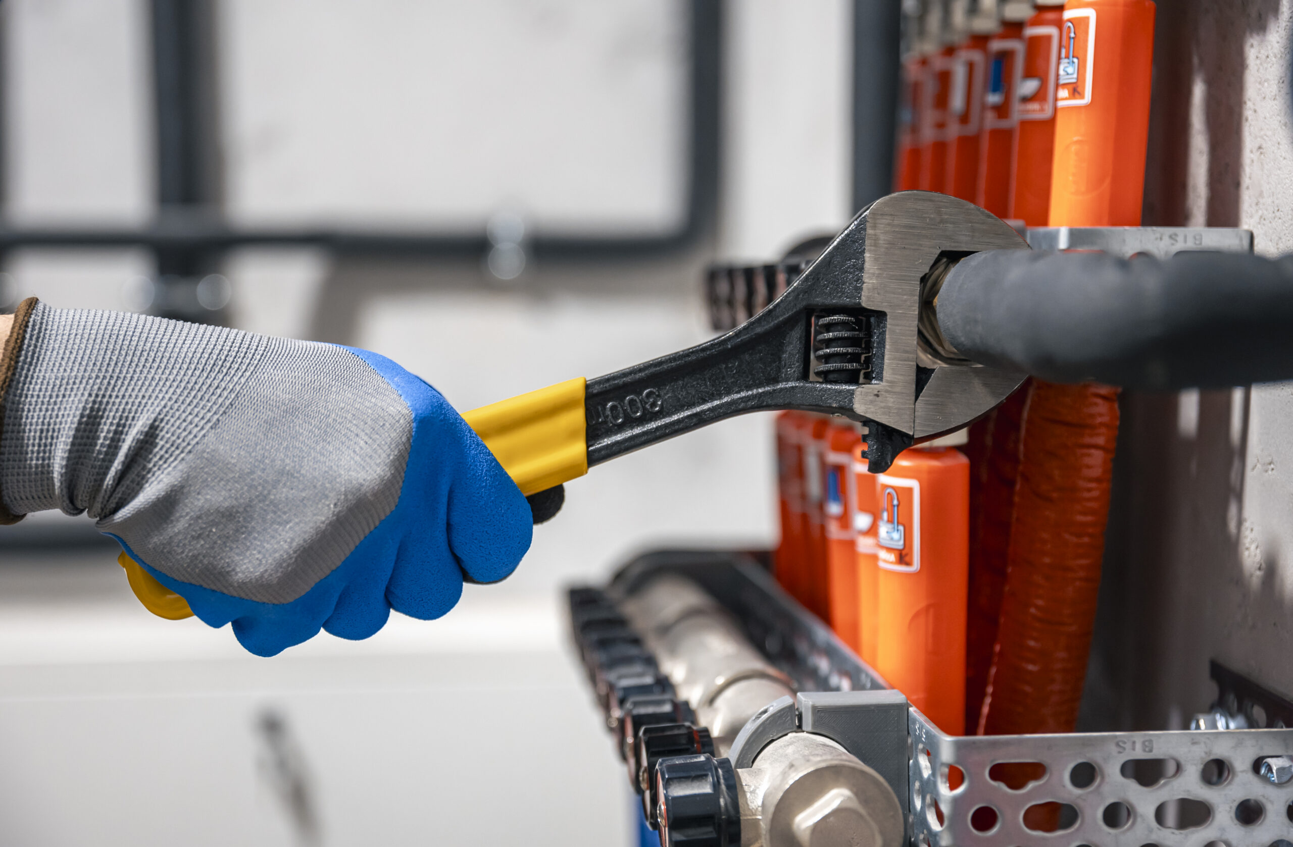male hands with a wrench turning off valves.