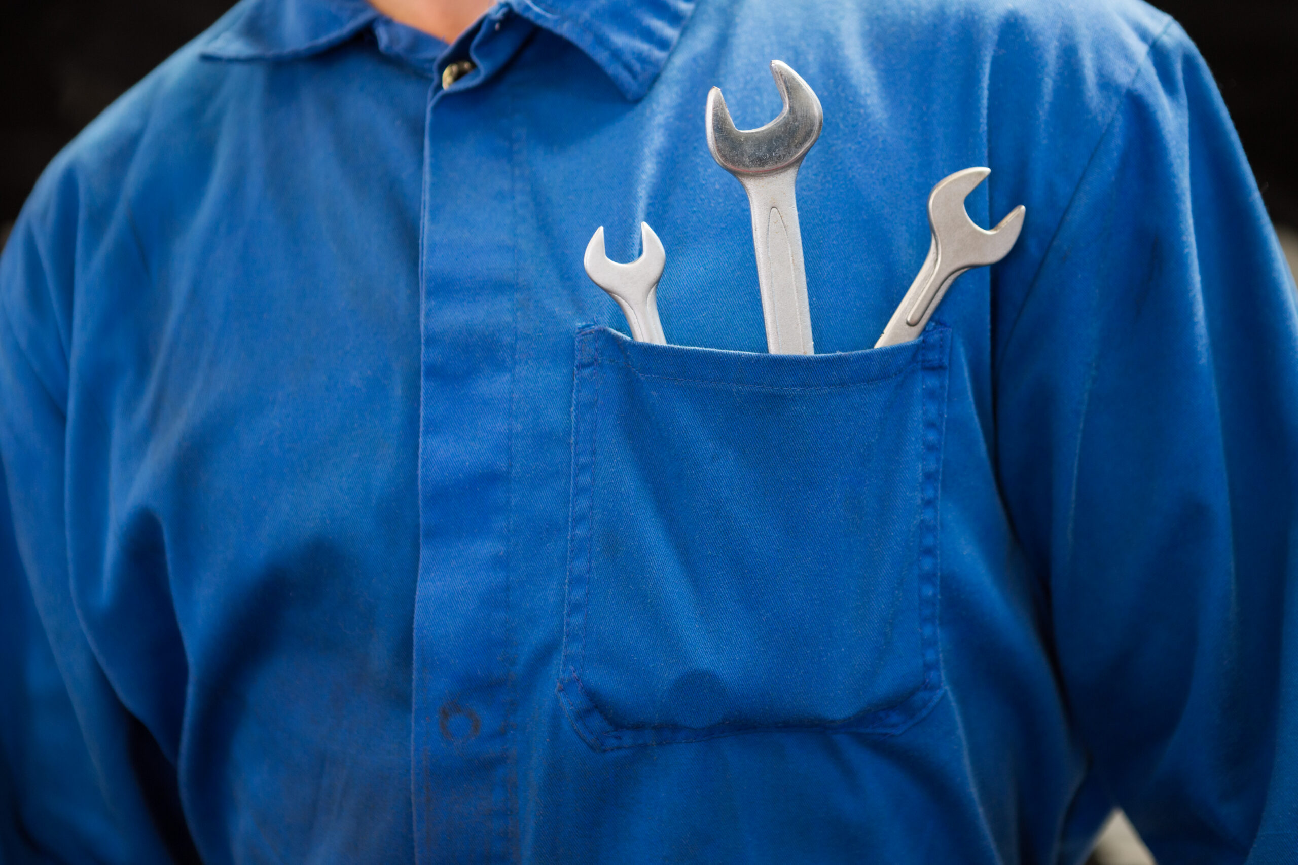 mechanic with wrenches in pocket at the repair garage